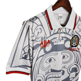 KODAA SPORT Mexico 1998 retro football jersey with Aztec-inspired graphic print, white with grey and red accents.