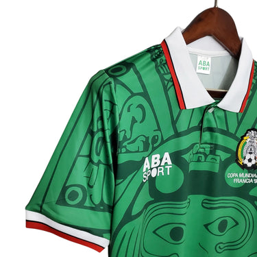 KODAA SPORT Mexico 1998 retro home football shirt, green with Aztec-inspired print, white collar with red trim.